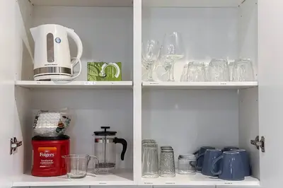 a cabinet filled with glasses and wine glasses at ~CozySpacious3bedroomRetreat~FREEparking•2.5bath in Edmonton