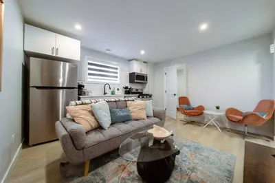 a living room with a couch and a kitchen at •SteamyRomanticBsmntSuite•KingBed•Wifi•Netflix in Edmonton