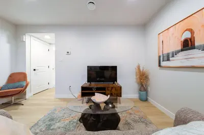 a living room with a tv and a table at •SteamyRomanticBsmntSuite•KingBed•Wifi•Netflix in Edmonton