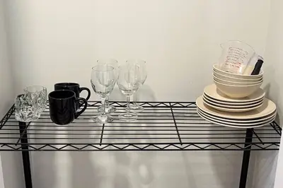 a glass table with plates and wine glasses on it at •SteamyRomanticBsmntSuite•KingBed•Wifi•Netflix in Edmonton
