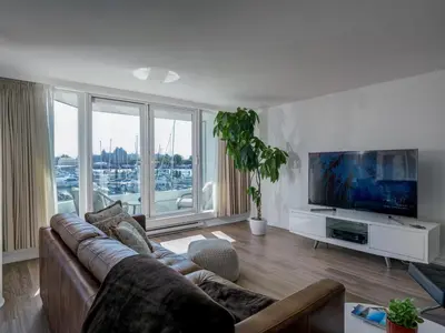 a living room with a couch and a flat screen tv at Coastal Duet - min 3-Day Stay Breathtaking Views with Work Desk by Victoria Prime! in Victoria