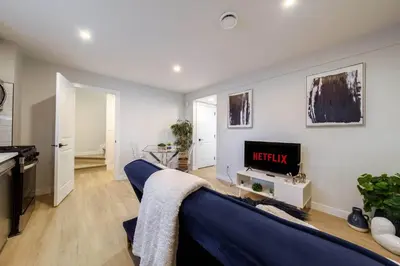 a living room with a blue couch and a tv at RoyalBlueBSMTsuite/KingBed/FreeParking/Netflix in Edmonton