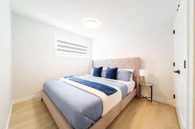 a bedroom with a large bed with blue pillows at RoyalBlueBSMTsuite/KingBed/FreeParking/Netflix in Edmonton