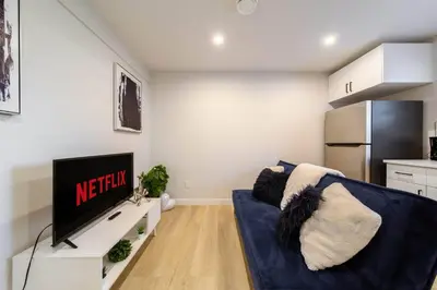 a living room with a blue couch and a tv at RoyalBlueBSMTsuite/KingBed/FreeParking/Netflix in Edmonton