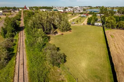 an aerial view of a field and train tracks at Prairie Junction Rustic Cabins Stettler in Stettler