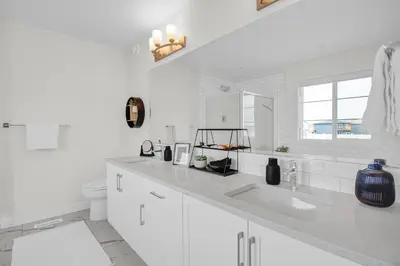 a white bathroom with a sink and a toilet at New Luxury Sleeps 7 AC Double Garage in Edmonton