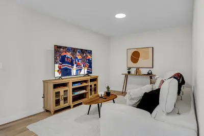 a living room with a couch and a tv at New Luxury Sleeps 7 AC Double Garage in Edmonton