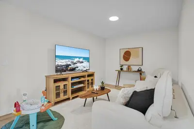 a living room with a white couch and a tv at New Luxury Sleeps 7 AC Double Garage in Edmonton