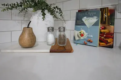 a counter with two glass bottles and a book and a vase at 1 BR Suite Stylish Coffee Station Stocked sleep 4 in Edmonton