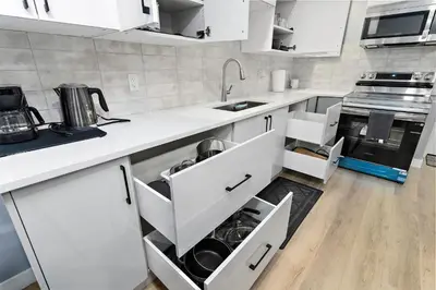 a kitchen with white cabinets and a sink at Blissful Nest - Cozy, Classy 2 Bedroom Private Suite Netflix, free Parking, 20 minutes to West Edmonton Mall and Airport in Edmonton
