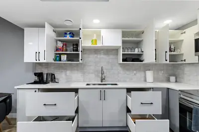 a kitchen with white cabinets and a sink at Blissful Nest - Cozy, Classy 2 Bedroom Private Suite Netflix, free Parking, 20 minutes to West Edmonton Mall and Airport in Edmonton