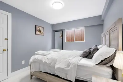 a bedroom with a large bed with blue walls at Stylish 3BR, 2BA Vancouver Home in Vancouver