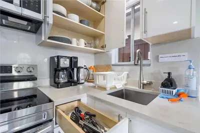 a kitchen with white cabinets and a sink at Stylish 3BR, 2BA Vancouver Home in Vancouver