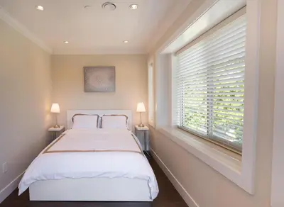 a bedroom with a bed and a window with blinds at Upscale 4BR Vancouver in Vancouver