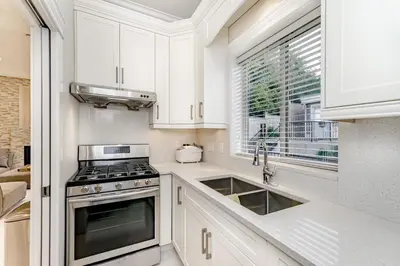 a kitchen with white cabinets and a stove and a window at Upscale 4BR Vancouver in Vancouver