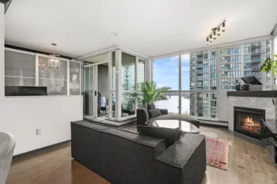 a living room with a fireplace and a couch at Large 1br Sub-Penthouse Near Science World in Vancouver