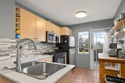 a kitchen with a sink and a stove at Charming 2 bedroom Duplex steps from Jericho Beach in Vancouver