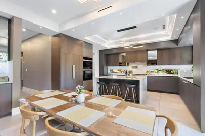 a kitchen and dining room with a wooden table and chairs at 2505 Edgemont Blvd.- Anupoju in North Vancouver