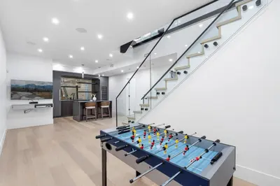 a ping pong table in a living room with stairs at 2505 Edgemont Blvd.- Anupoju in North Vancouver