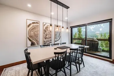 a dining room with a table and chairs and a large window at Ravencrest 309 by Outpost Whistler in Whistler