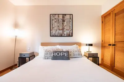a bedroom with a white bed with two night stands at Taluswood 6 by Outpost Whistler in Whistler