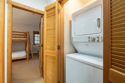 a kitchen with a refrigerator and a bunk bed at Taluswood 6 by Outpost Whistler in Whistler