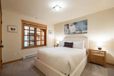 a bedroom with a large white bed and a window at Taluswood 14 by Outpost Whistler in Whistler