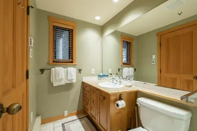 a bathroom with a sink and a toilet and a mirror at Taluswood 14 by Outpost Whistler in Whistler