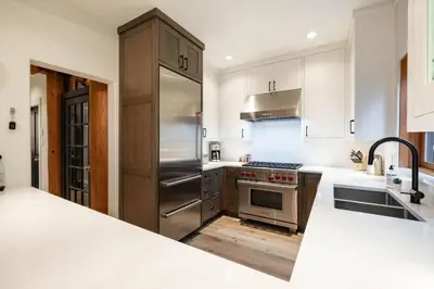 a kitchen with stainless steel appliances and white cabinets at Taluswood 36 by Outpost Whistler in Whistler