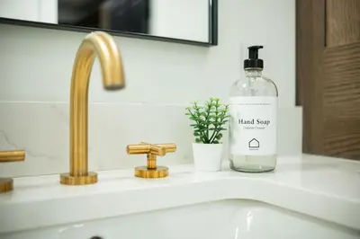 a bottle of hand soap sitting on a bathroom sink at Taluswood 36 by Outpost Whistler in Whistler