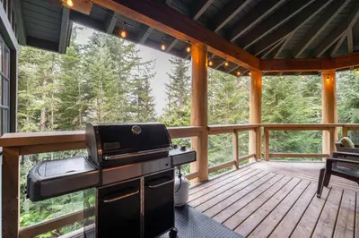 a screened in porch with a grill on a deck at Taluswood 36 by Outpost Whistler in Whistler