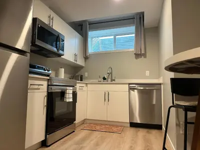 a kitchen with white cabinets and a microwave at Oisede in Edmonton