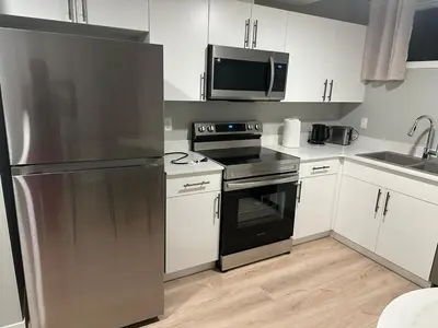 a kitchen with a stainless steel refrigerator and a microwave at Oisede in Edmonton