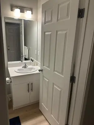 a bathroom door with a sink and a mirror at Oisede in Edmonton