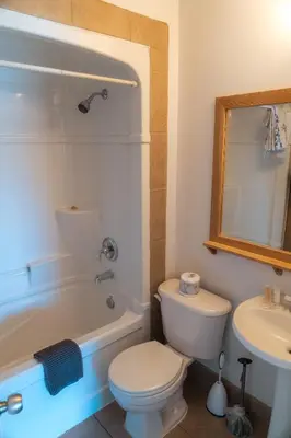 a bathroom with a toilet and a tub and a sink at Little Beach Resort in Ucluelet