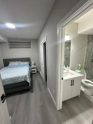 a bedroom with a bed and a sink and a toilet at Beautiful 2 bedroom 2 bath in NW Calgary in Calgary