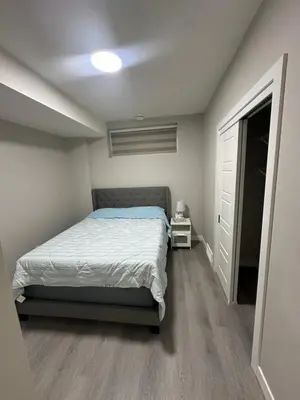 a small bedroom with a bed and a closet at Beautiful 2 bedroom 2 bath in NW Calgary in Calgary
