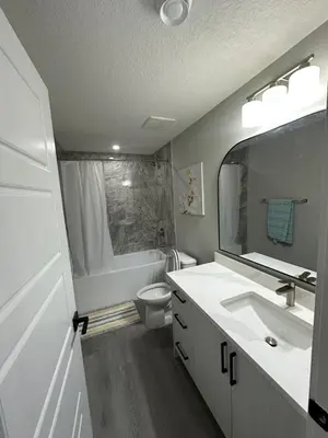 a bathroom with a sink and a toilet and a mirror at Beautiful 2 bedroom 2 bath in NW Calgary in Calgary