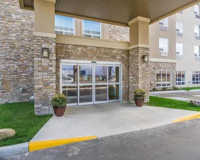 a building with two potted plants in front of it at Comfort Inn & Suites Edmonton International Airport in Nisku