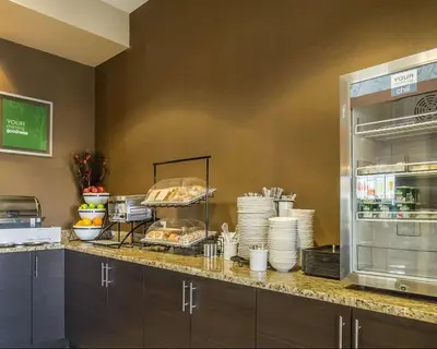 a kitchen with a counter with plates and food at Comfort Inn & Suites Edmonton International Airport in Nisku