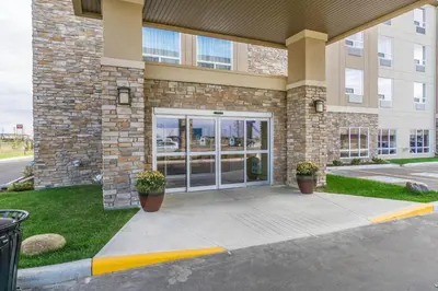a front door of a building with two potted plants at Comfort Inn & Suites Edmonton International Airport in Nisku