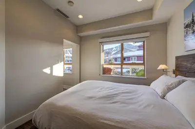 a bedroom with a white bed and a window at Tyndall Stone 317 by Outpost Whistler in Whistler