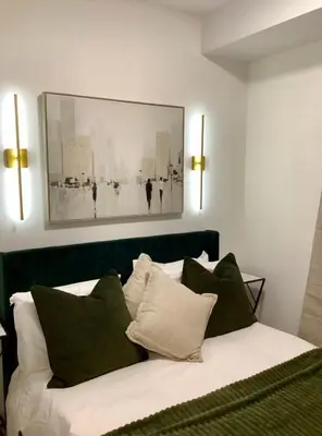 a bedroom with a bed with green and white pillows at City Center Olive Grove in Kamloops
