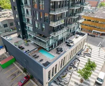 an aerial view of a tall building with a pool at MicroNest - Modern Overlooking Downtown Parking in Calgary