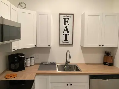 a kitchen with white cabinets and a kitchen sink at Sapphire Lux Queen Suite in Kamloops