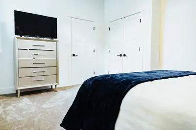 a bedroom with a bed and a flat screen tv at Sapphire Lux Queen Suite in Kamloops