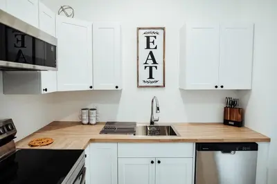a kitchen with white cabinets and a sink at Sapphire Lux Queen Suite in Kamloops