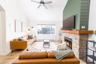 a living room with a couch and a fireplace at Wintergreen Retreat w/Hot Tub by Village in Kelowna