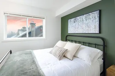 a bedroom with a bed and a window at Wintergreen Retreat w/Hot Tub by Village in Kelowna