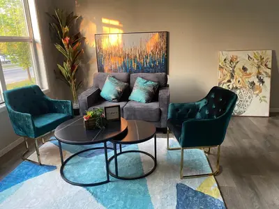 a living room with a couch and two chairs and a table at Mahogany's Comfy Haven in Calgary